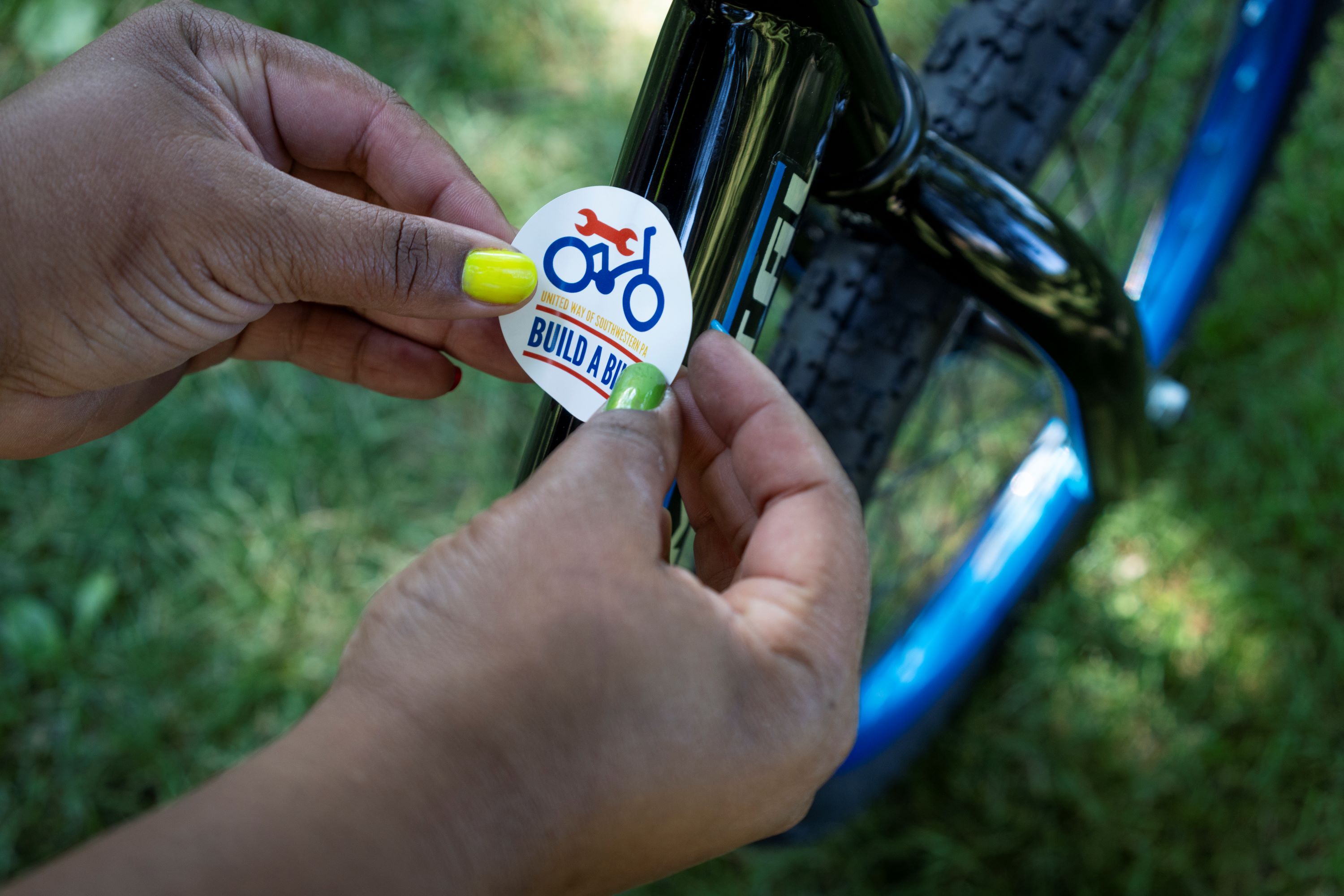 Build a Bike sticker being place on a bike.