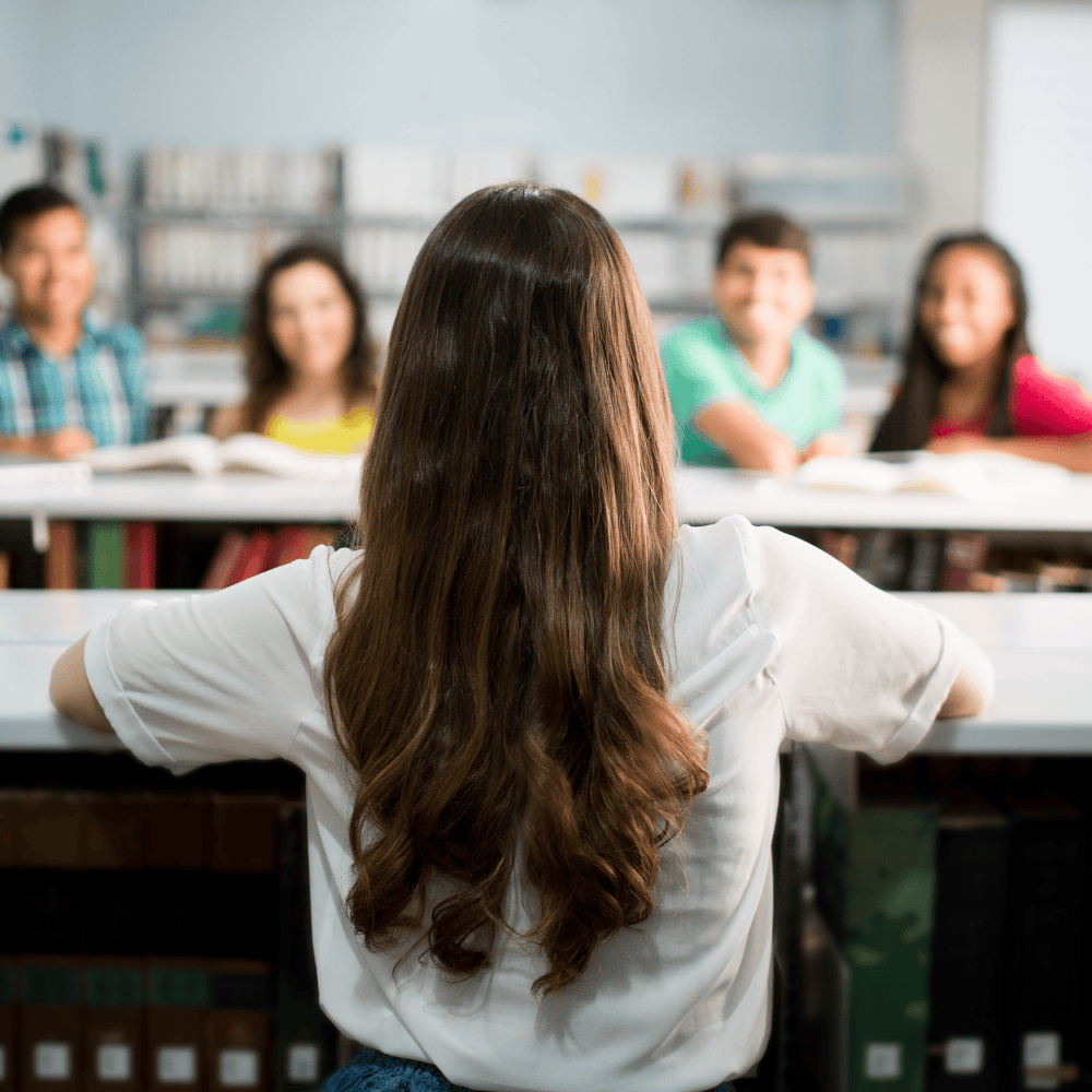 young girl facing other students in foreground